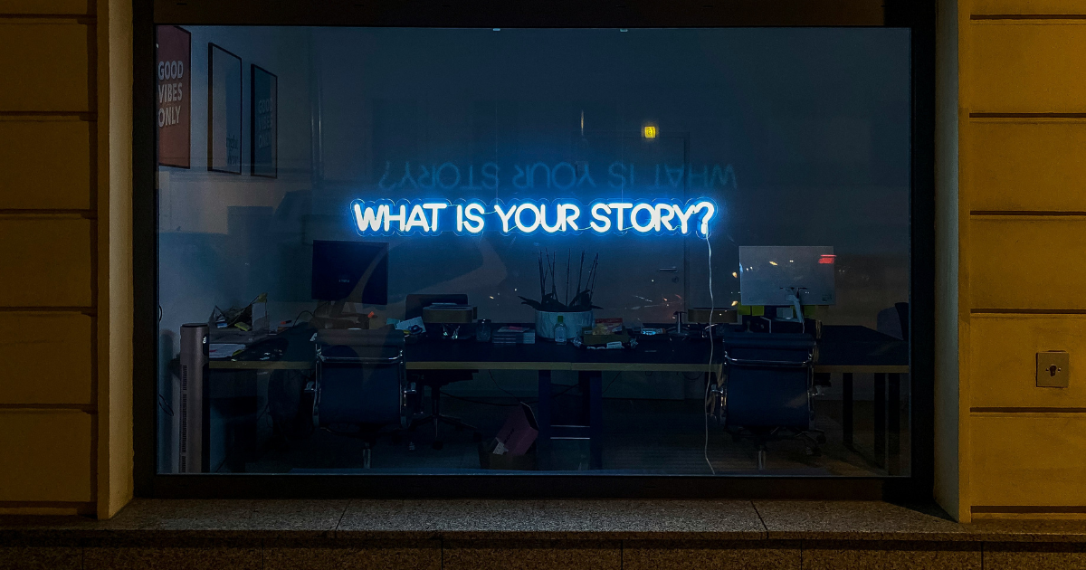 Store window with sign reading "What is your story?"